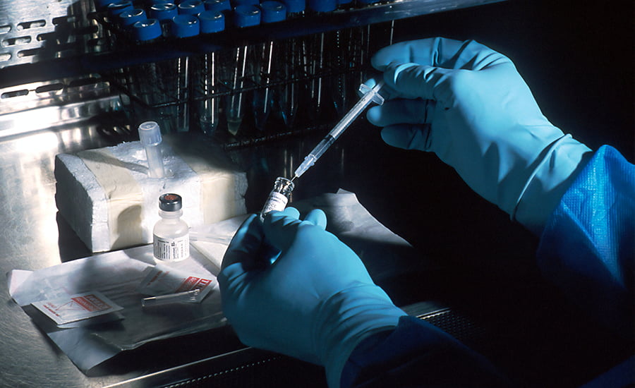 Scientifique qui prélève un liquide dans une pipette